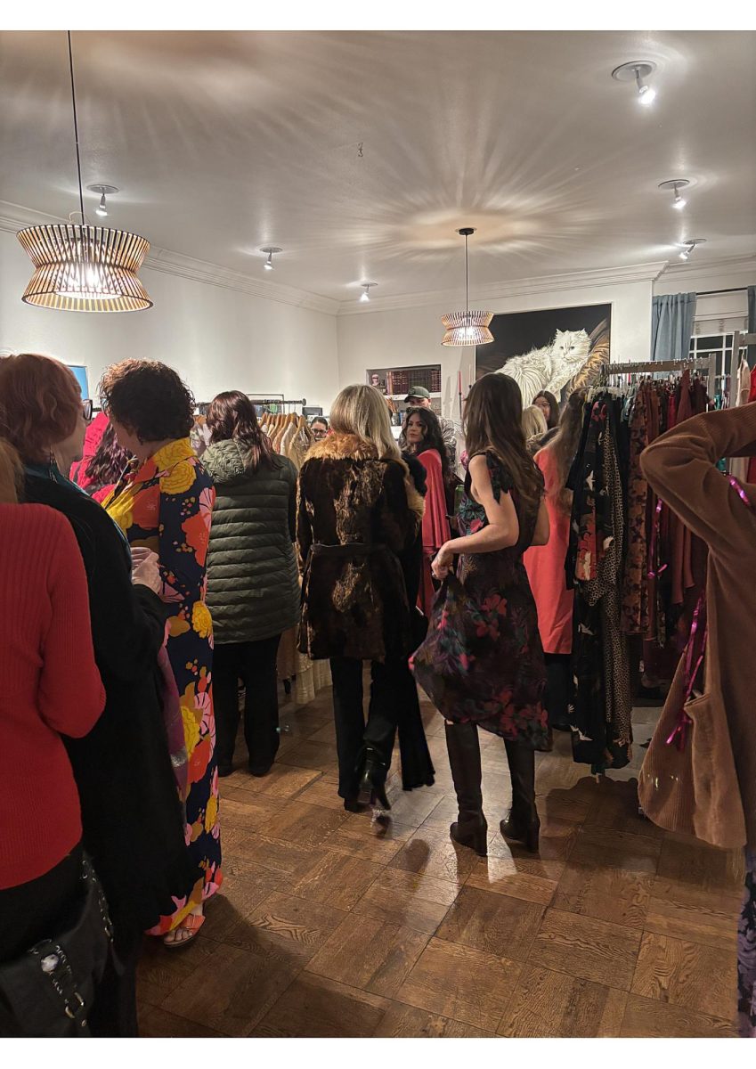 Guests browse vintage clothing racks in the Enloe Mansion living room for Galentine's Sip and Shop Event. Photo taken by Sydney Davis on Feb. 13, 2026