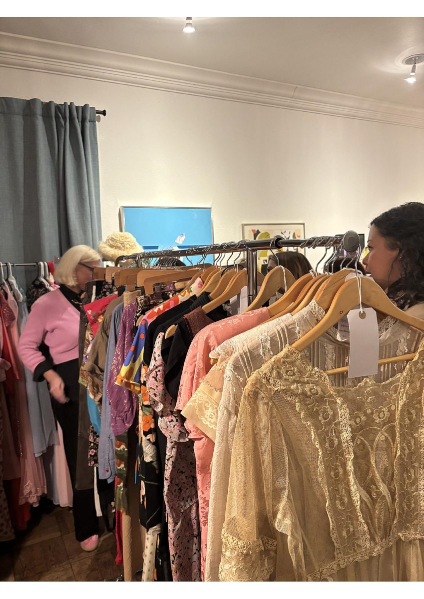Shoppers gather around a clothing rack filled with vintage finds from local women-owned vendors. Photo taken by Sydney Davis on Feb. 13, 2026