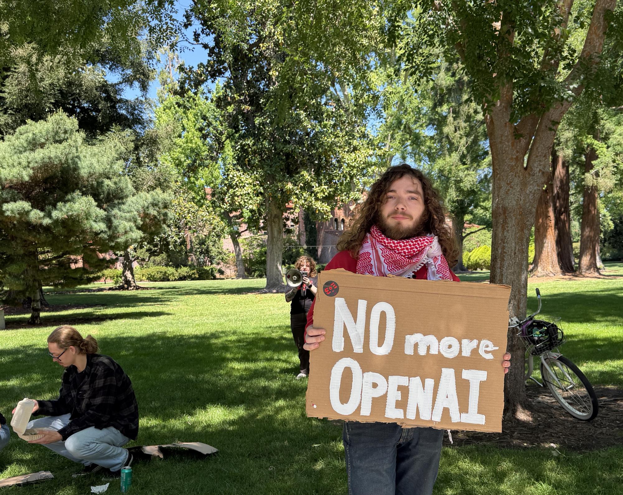 James Carlson joins the CSU-wide protest to divest from OpenAI while Kat Anderson speaks about the negative impacts of AI in the background. 
Photo taken by Alexa Lima on April 23, 2026. 