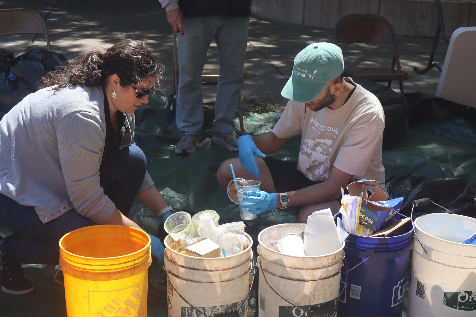 Jillian Leach and Ibaad Mohammad, along with the rest of the team, dealt with plenty of liquids throughout the day. They noted that liquids could contaminate the recyclable material and any items should be emptied before reaching the recycling bin. Photo taken by Chris Hutton on April 16, 2026.